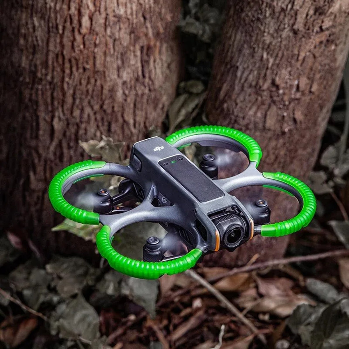 DJI Avata 2 mit STARTRC Anti-Kollisionsringen im Flug vor Baumstämmen