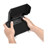 DJI RC Pro mit aufgeklappter STARTRC Sonnenblende in der Hand